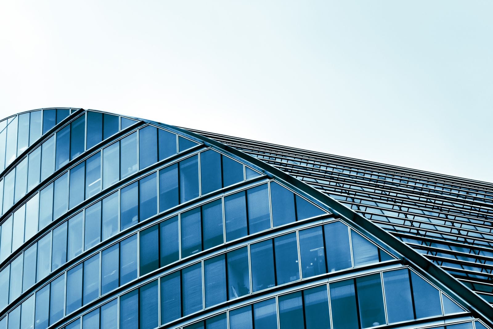 Curved glass facade of a modern building against the sky